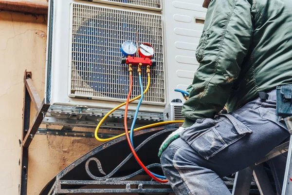 AC repair technician servicing outdoor unit in West Bloomfield MI