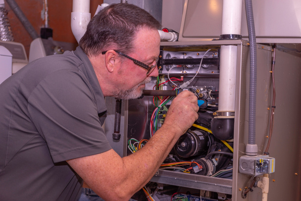 Furnace repair service West Bloomfield MI — technician working on furnace
